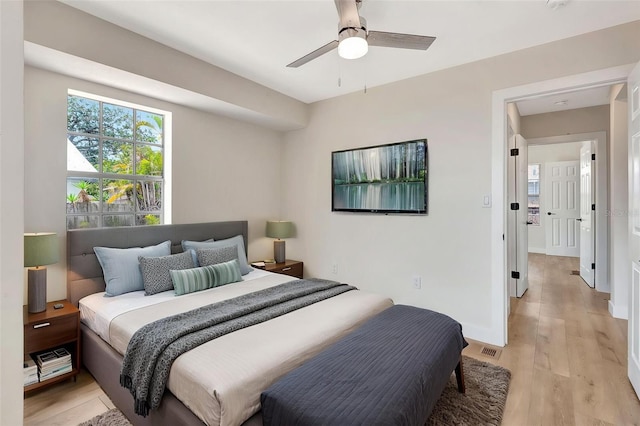 bedroom featuring light wood finished floors, a ceiling fan, and baseboards