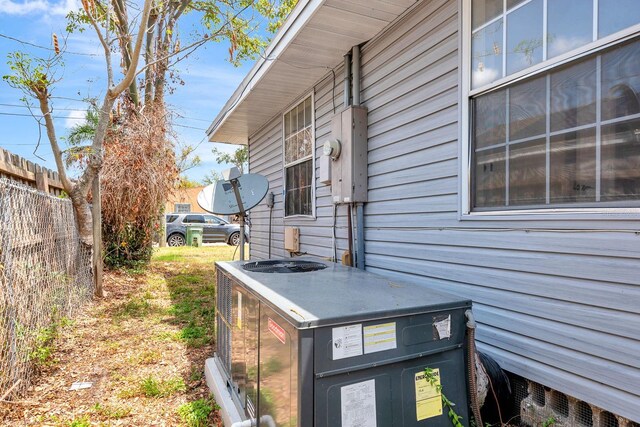 exterior view of central AC unit, fence, electric meter, and a satellite dish