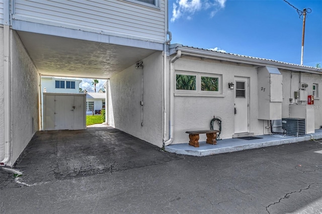 view of side of property with central AC and an attached carport