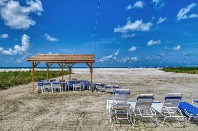 view of patio / terrace featuring view of water and beach