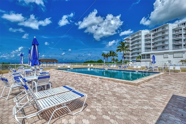community pool with fence and a patio area