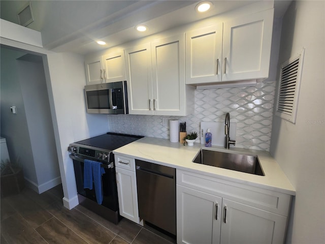 5858 Midnight Pass Rd Unit 27, Sarasota, FL 34242 - kitchen with appliances with stainless steel finishes, a sink, white cabinetry, light countertops, and recessed lighting