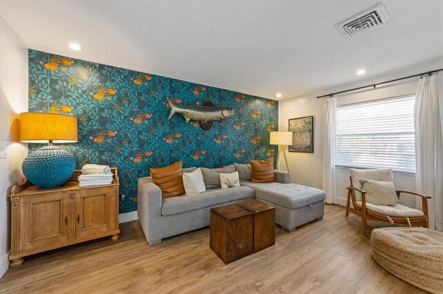 205 71st St Unit B, Holmes Beach, FL 34217 - living room with wallpapered walls, an accent wall, light wood-type flooring, baseboards, and recessed lighting