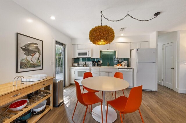 205 71st St Unit B, Holmes Beach, FL 34217 - kitchen featuring white appliances, wood finished floors, tasteful backsplash, light countertops, and white cabinetry