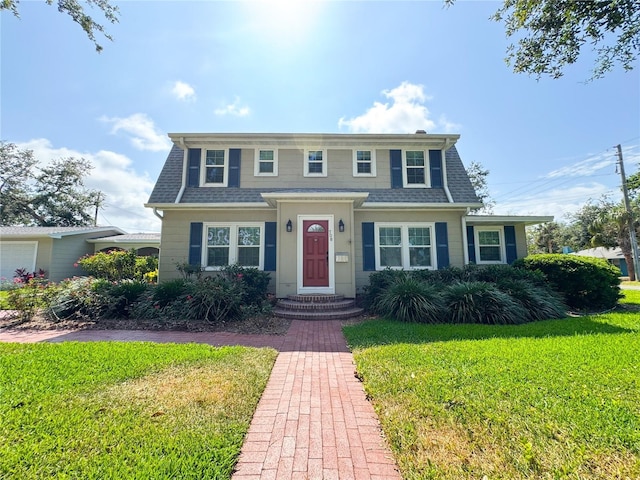 view of front of house with a front lawn and roof with shingles