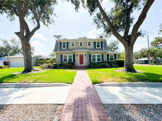 view of front facade featuring a front yard, a garage, and roof with shingles