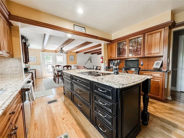 kitchen featuring brown cabinetry, light wood-style flooring, dark cabinets, beamed ceiling, and black electric stovetop