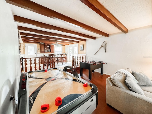 playroom with beamed ceiling, dark wood finished floors, a ceiling fan, and baseboards