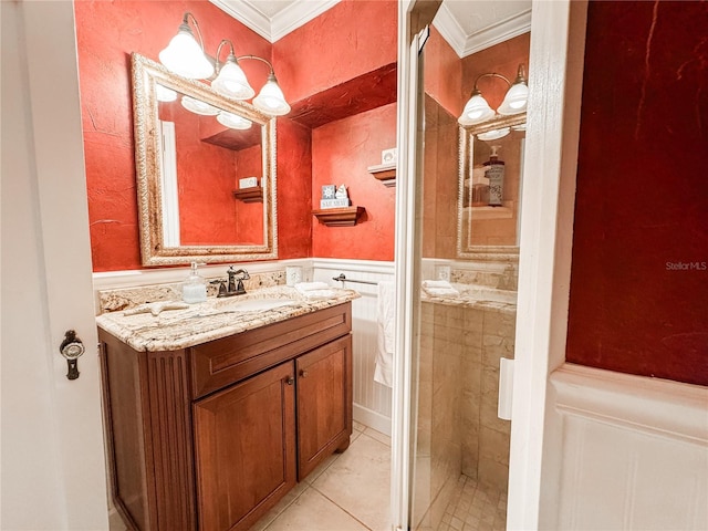 bathroom with crown molding, a wainscoted wall, tile patterned floors, and vanity