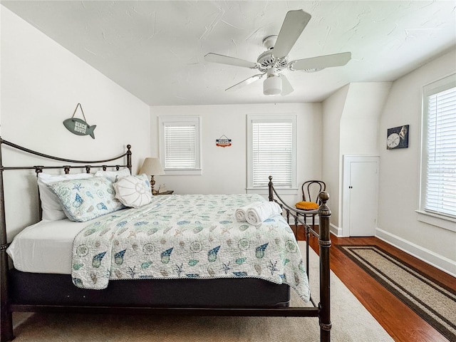 bedroom with wood finished floors, baseboards, and ceiling fan