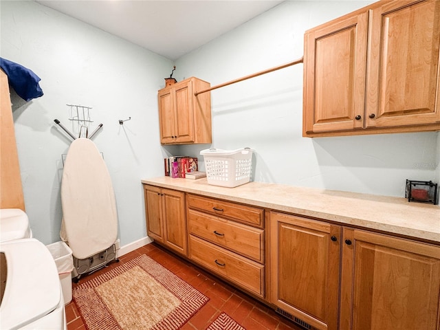 washroom featuring cabinet space, dark wood-type flooring, and baseboards