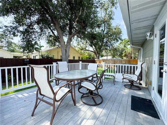 wooden deck with a fenced backyard, outdoor dining space, and central air condition unit