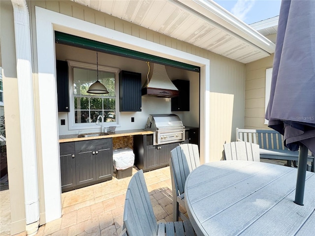 view of patio / terrace with a sink, exterior kitchen, a grill, and outdoor dining space