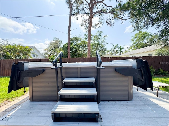 view of patio featuring a hot tub and a fenced backyard