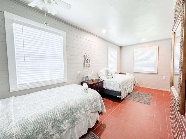bedroom with brick patterned floors, wood walls, and ceiling fan