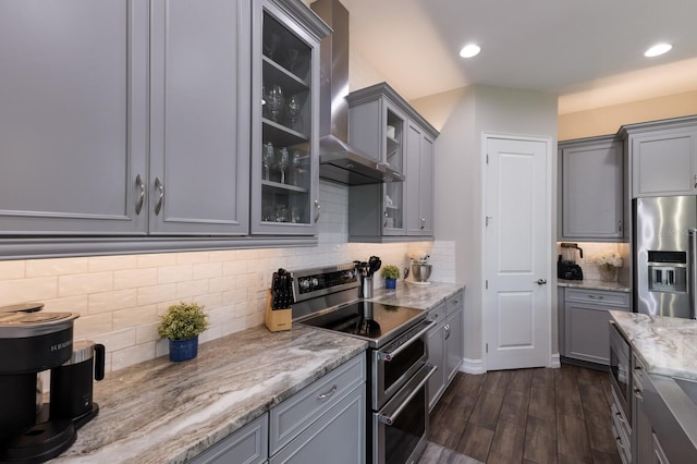 11513 11th Ave E, Bradenton, FL 34212 - kitchen featuring appliances with stainless steel finishes, gray cabinetry, wall chimney exhaust hood, dark wood finished floors, and decorative backsplash