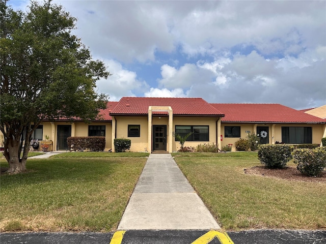 1214 56th St W Unit 1214, Bradenton, FL 34209 - view of front of house featuring a tile roof, a front yard, and stucco siding