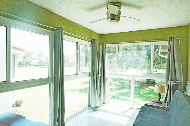 sunroom featuring a textured ceiling, tile patterned flooring, and a textured wall