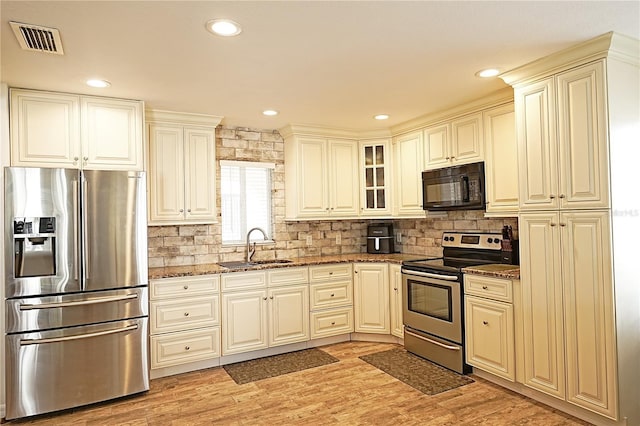 802 Capri Isles Blvd Unit 231, Venice, FL 34292 - kitchen with stainless steel appliances, a sink, dark stone counters, decorative backsplash, and recessed lighting
