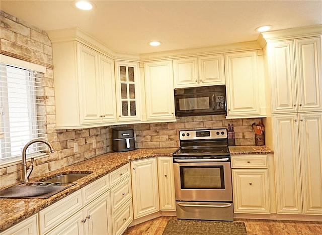 802 Capri Isles Blvd Unit 231, Venice, FL 34292 - kitchen featuring black microwave, electric range, a sink, backsplash, and stone countertops
