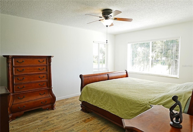 802 Capri Isles Blvd Unit 231, Venice, FL 34292 - bedroom with wood finished floors, a textured ceiling, baseboards, and ceiling fan