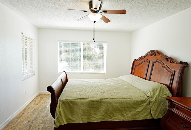 802 Capri Isles Blvd Unit 231, Venice, FL 34292 - bedroom with light wood-style floors, baseboards, a textured ceiling, and ceiling fan