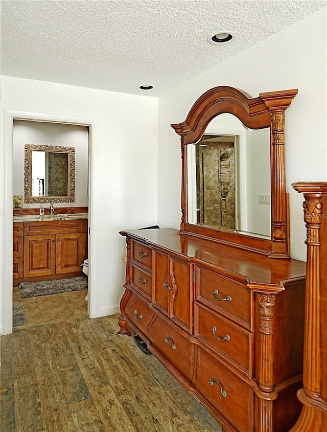802 Capri Isles Blvd Unit 231, Venice, FL 34292 - hallway featuring a textured ceiling, dark wood finished floors, and a sink