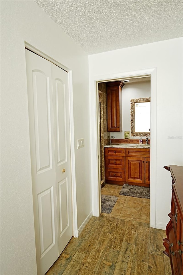 802 Capri Isles Blvd Unit 231, Venice, FL 34292 - bathroom with wood finished floors, vanity, and a textured ceiling