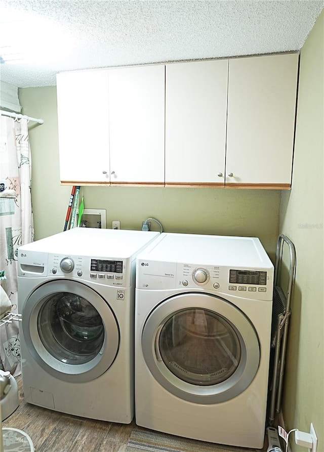 802 Capri Isles Blvd Unit 231, Venice, FL 34292 - laundry area with cabinet space, washing machine and clothes dryer, wood finished floors, and a textured ceiling
