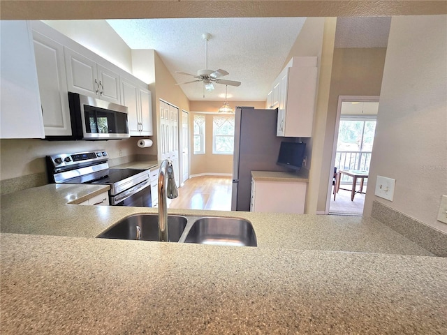 7201 29th Avenue Dr W Unit 306, Bradenton, FL 34209 - kitchen with appliances with stainless steel finishes, a sink, a textured ceiling, white cabinetry, and lofted ceiling