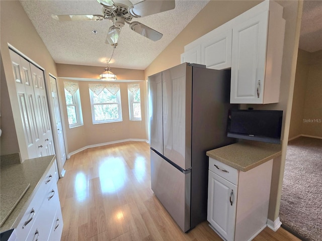 7201 29th Avenue Dr W Unit 306, Bradenton, FL 34209 - kitchen featuring ceiling fan, freestanding refrigerator, white cabinets, a textured ceiling, and light wood-style floors