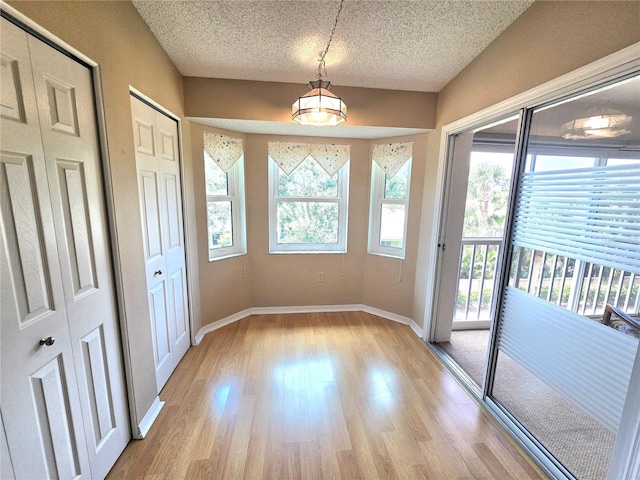 7201 29th Avenue Dr W Unit 306, Bradenton, FL 34209 - entryway with healthy amount of natural light, a textured ceiling, light wood-type flooring, and baseboards