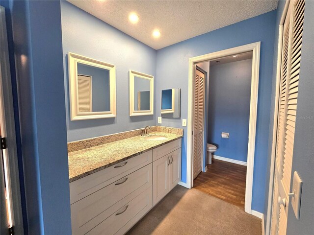 7201 29th Avenue Dr W Unit 306, Bradenton, FL 34209 - bathroom featuring toilet, vanity, baseboards, a textured ceiling, and recessed lighting