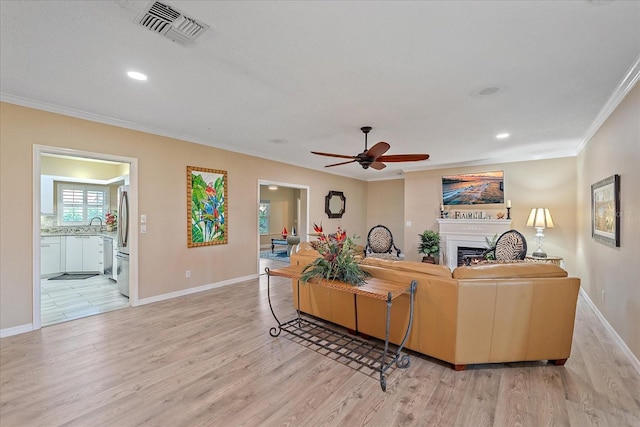 1432 Colony Pl, Venice, FL 34292 - living room featuring crown molding, light wood finished floors, ceiling fan, a fireplace, and recessed lighting