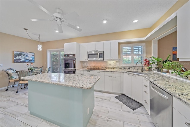 1432 Colony Pl, Venice, FL 34292 - kitchen featuring appliances with stainless steel finishes, a sink, a kitchen island, plenty of natural light, and recessed lighting