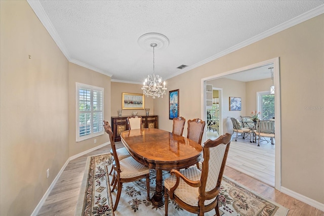 1432 Colony Pl, Venice, FL 34292 - dining space with healthy amount of natural light, a textured ceiling, a chandelier, light wood-style flooring, and crown molding