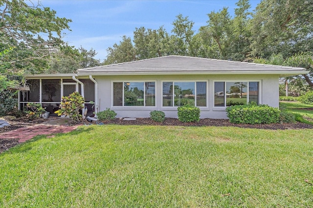 1432 Colony Pl, Venice, FL 34292 - rear view of house with a sunroom, a yard, and stucco siding