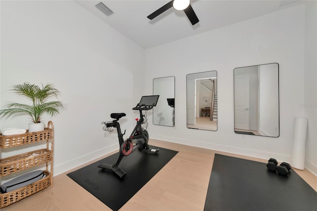 exercise area featuring ceiling fan, wood finished floors, and baseboards