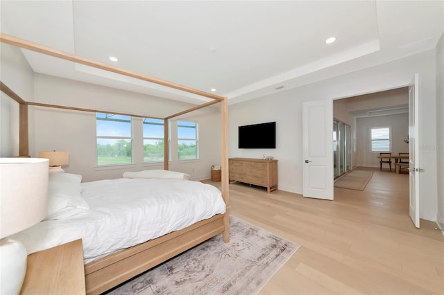 bedroom with multiple windows, light wood-type flooring, recessed lighting, and baseboards