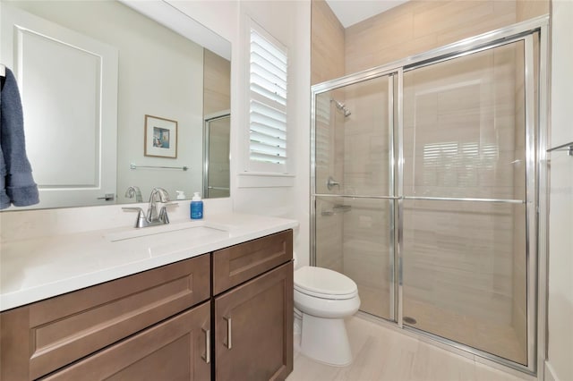 bathroom with a stall shower, toilet, and vanity
