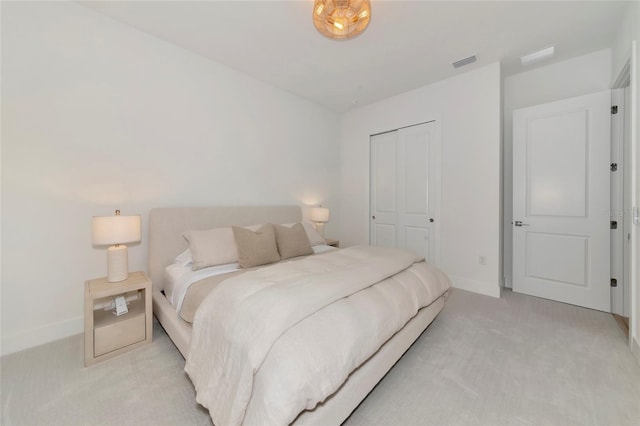 bedroom with light carpet, a closet, and baseboards