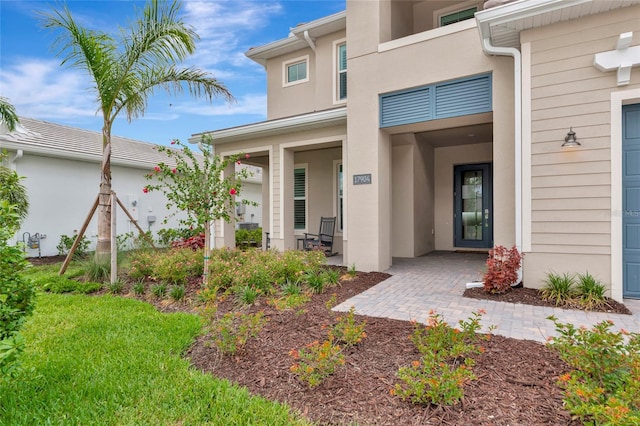 entrance to property with stucco siding and a porch