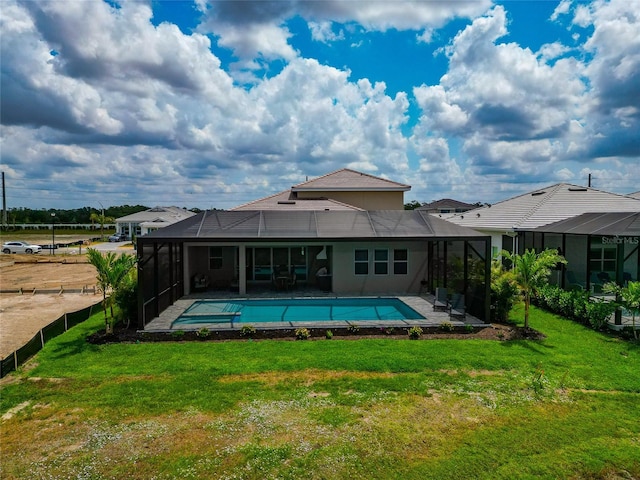 rear view of house with a lanai, a patio area, and a pool with connected hot tub