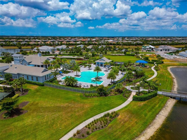 aerial view of residential area featuring a pool and a nearby body of water