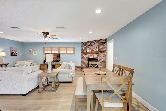 living area featuring a fireplace, ceiling fan, light wood-type flooring, and recessed lighting