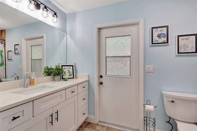 full bathroom featuring toilet, vanity, and baseboards