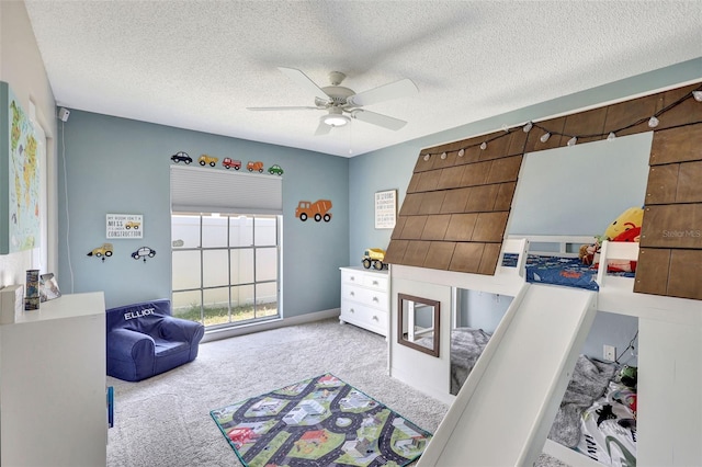 carpeted bedroom featuring a textured ceiling and a ceiling fan