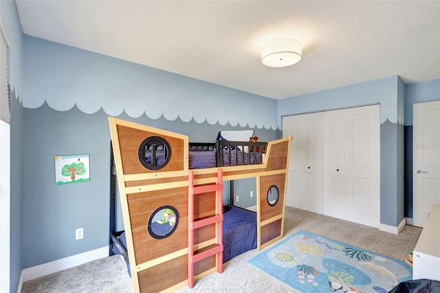carpeted bedroom with a closet, a textured ceiling, and baseboards
