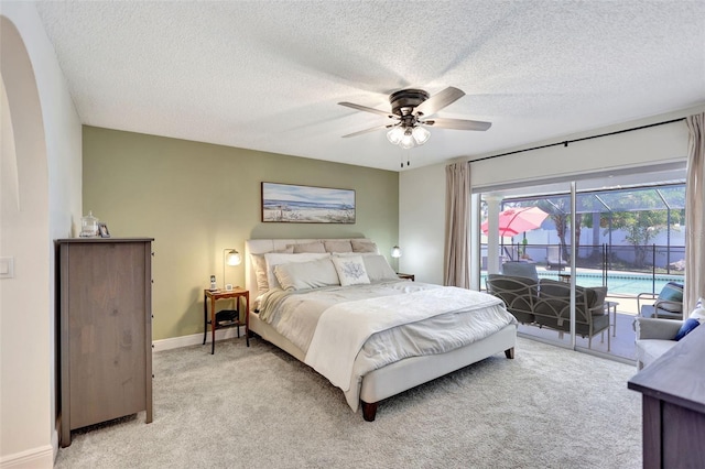 bedroom featuring access to exterior, light colored carpet, a textured ceiling, baseboards, and ceiling fan