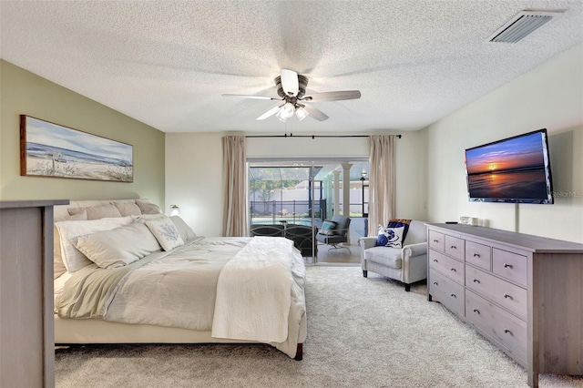 bedroom featuring access to exterior, light colored carpet, a ceiling fan, and a textured ceiling